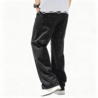 Black pants with star pattern worn by a person on a white background