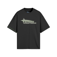 Black oversized WG Uplifted Tee, front view with the sage green Witness Greatness star wordmark across the chest and contrast green side seam stitching