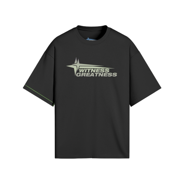 Black oversized WG Uplifted Tee, front view with the sage green Witness Greatness star wordmark across the chest and contrast green side seam stitching