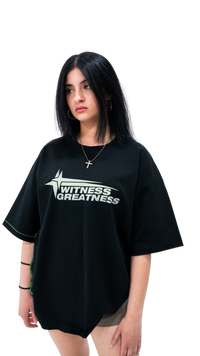 Model wearing the oversized black WG Uplifted Tee, front view with the mint green Witness Greatness star logo and boxy drop shoulder fit