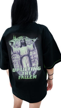 Model wearing the WG Uplifted Tee from behind, showing the Uplifting the Fallen Christ graphic and neon green contrast stitching on the side seam